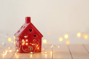 Small house with glowing garland on white table